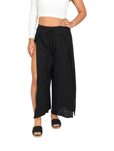 Mujer vistiendo pantalón negro de pierna ancha con abertura lateral y cintura ajustable.