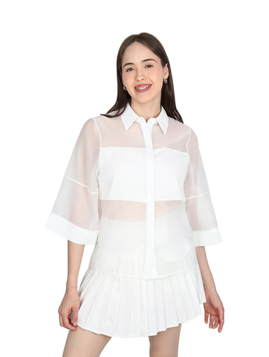 Mujer vistiendo blusa de organza blanca con mangas kimono y cuello camisero.