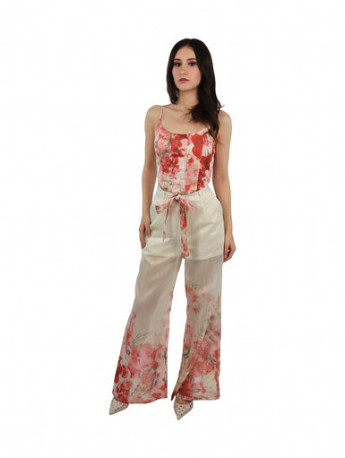 Pantalón ancho color beige con estampado floral en tonos rojos y rosas, incluye lazo en la cintura.