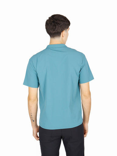 Hombre vistiendo camisa ATOK de manga corta en color azul claro con dos bolsillos frontales estilo outdoor.