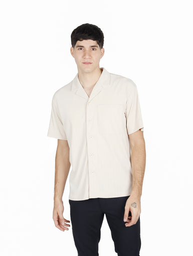 Hombre vistiendo camisa de manga corta color khaki con cuello abierto y bolsillo frontal.