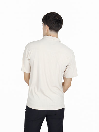 Hombre vistiendo camisa de manga corta color khaki con cuello abierto y bolsillo frontal.