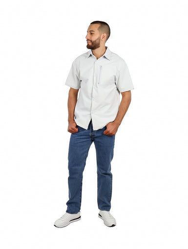 Hombre vistiendo camisa de manga corta color gris claro con bolsillo superior con cierre zipper.