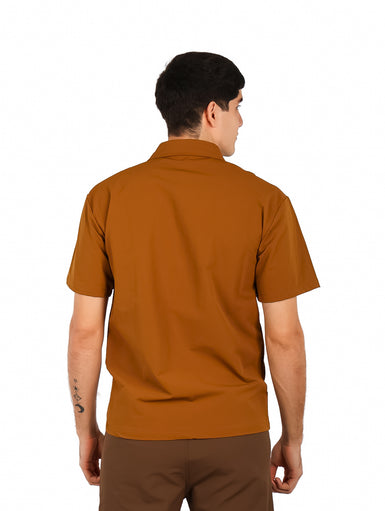 Hombre vistiendo camisa casual color café de manga corta con un bolsillo superior con cierre zipper.