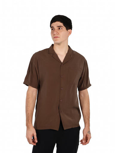 Hombre vistiendo una camisa básica de manga corta en color café con cuello abierto y botones.