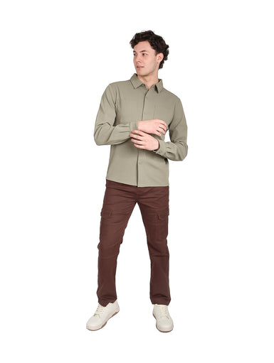 Hombre vistiendo una camisa casual de color verde con manga larga y dos bolsillos frontales.