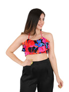 Mujer vistiendo un top corto multicolor con volantes y tirantes delgados.