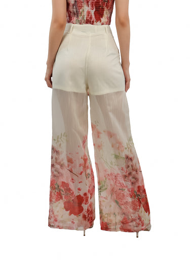 Pantalón ancho color beige con estampado floral en tonos rojos y rosas, incluye lazo en la cintura.