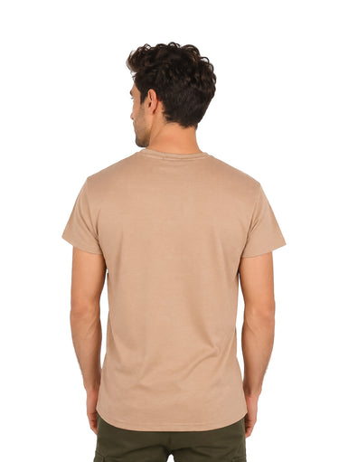 Hombre vistiendo una camiseta básica de color beige con cuello redondo y manga corta.