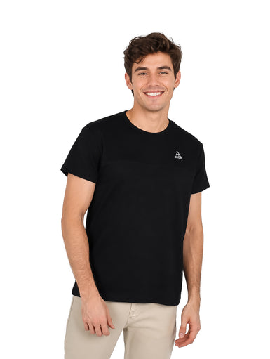 Hombre vistiendo una camiseta básica de manga corta color negro con un pequeño logo blanco en el pecho.