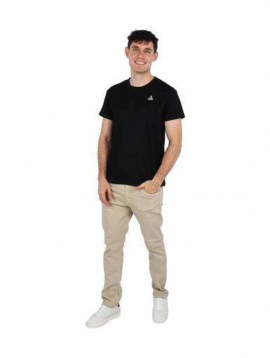 Hombre vistiendo una camiseta básica de manga corta color negro con un pequeño logo blanco en el pecho.