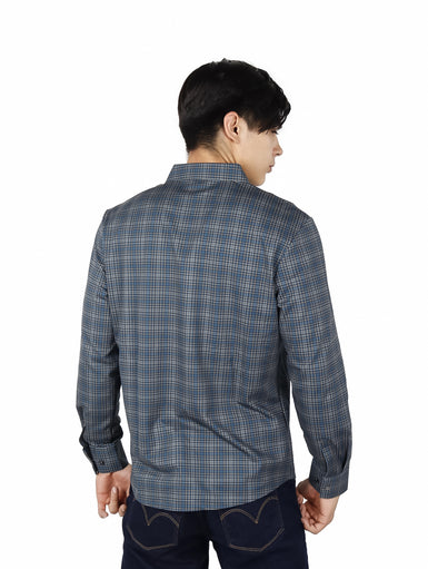 Hombre vistiendo una camisa casual de manga larga con estampado de cuadros en tonos verde y azul.