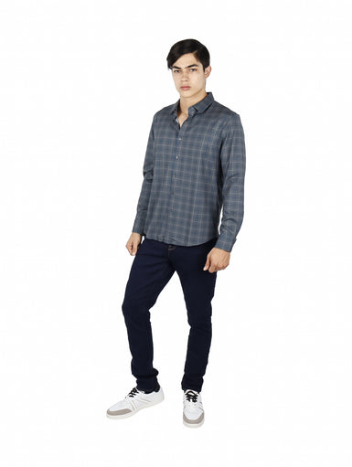 Hombre vistiendo una camisa casual de manga larga con estampado de cuadros en tonos verde y azul.