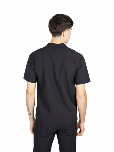 Hombre vistiendo camisa ATOK de manga corta color negro con dos bolsillos frontales y estilo outdoor.