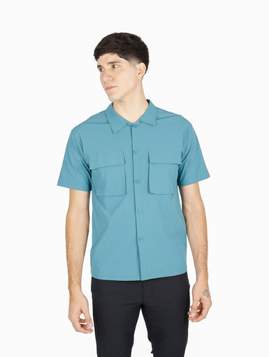 Hombre vistiendo camisa ATOK de manga corta en color azul claro con dos bolsillos frontales estilo outdoor.