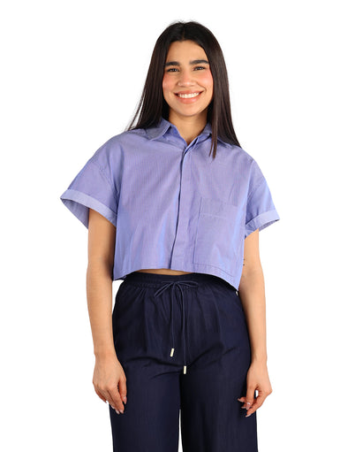 Mujer vistiendo una camisa corta de color azul oscuro con rayas finas y mangas cortas dobladas.
