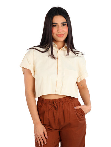 Mujer vistiendo una camisa corta color apricot con rayas finas y manga corta.