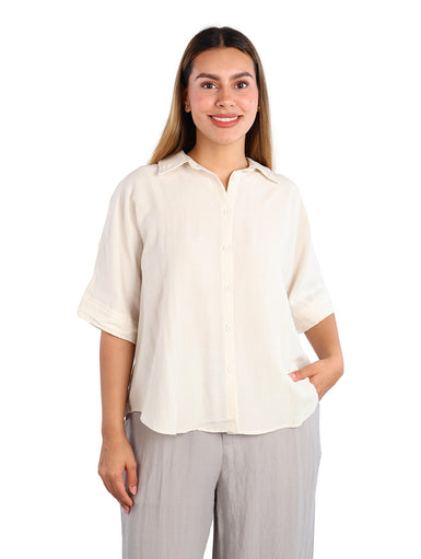 Mujer vistiendo una camisa de color linen con manga corta y botones frontales, estilo casual.